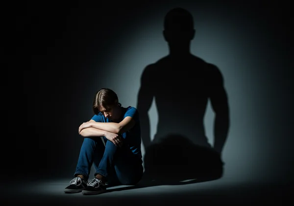 A person looking drained while another's shadow looms over.